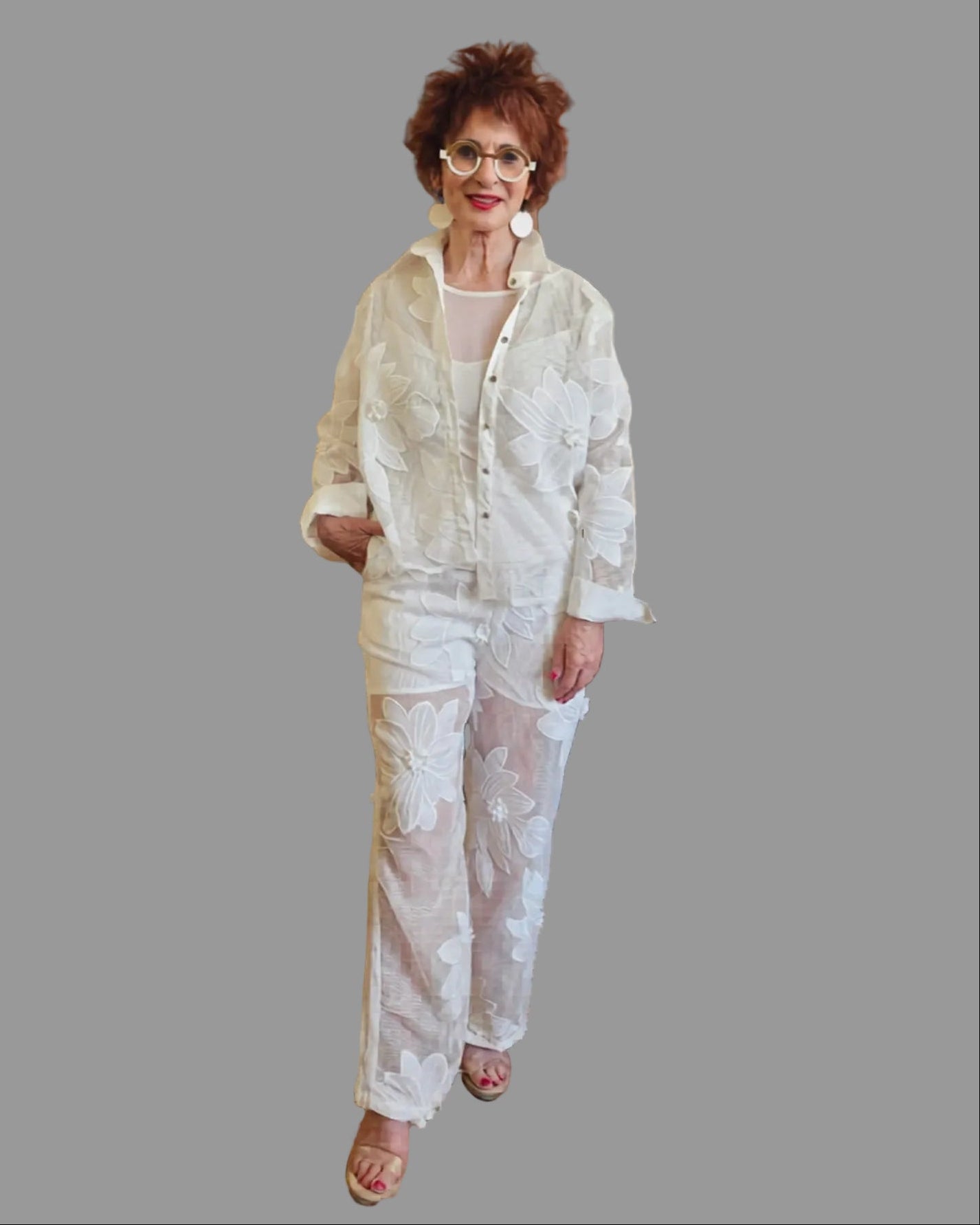 Woman wearing a light-colored outfit on a gray background