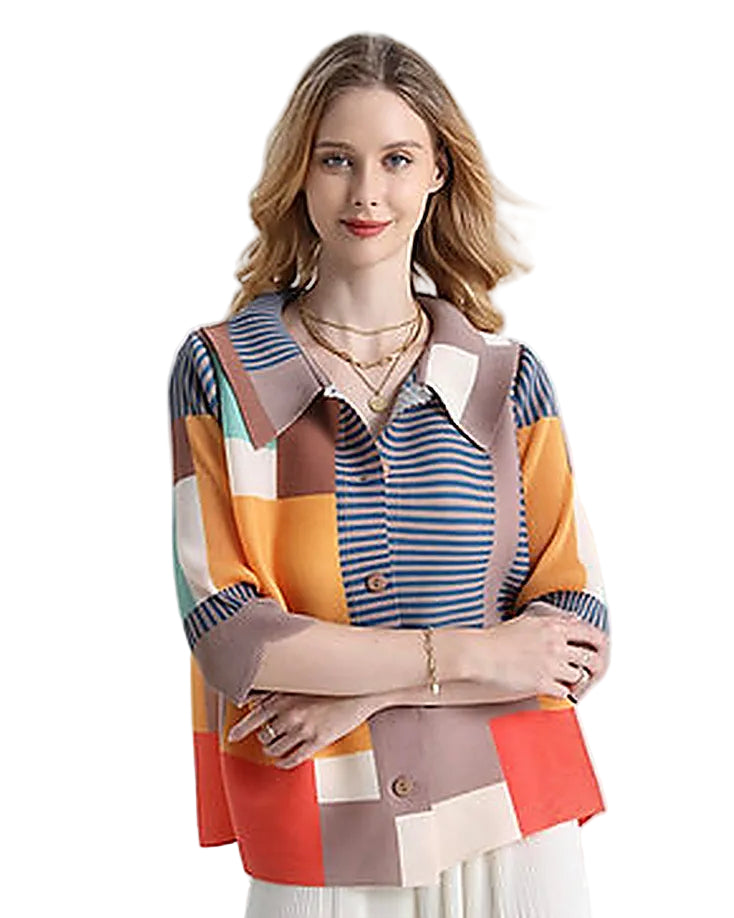 Woman wearing a colorful patchwork shirt with a plain background