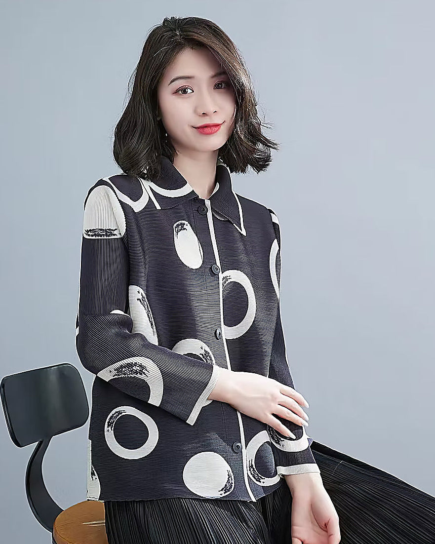 Woman wearing a black and white patterned jacket against a gray background
