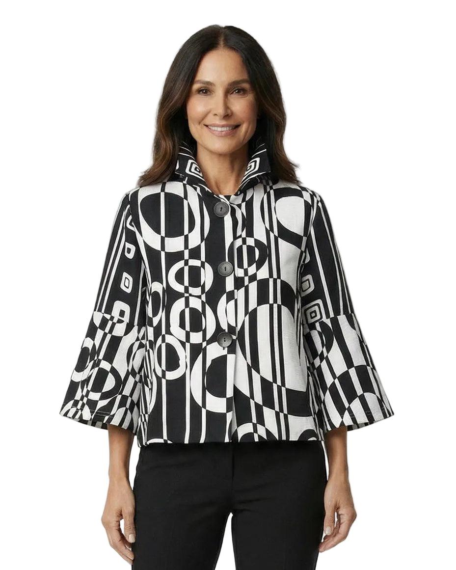 Woman wearing a black and white patterned blouse with black pants on a white background