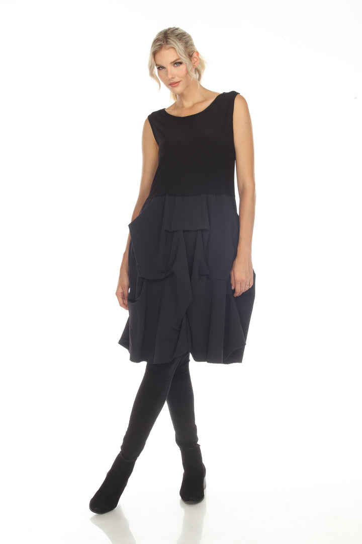 Woman wearing a black sleeveless top and layered black skirt on a white background