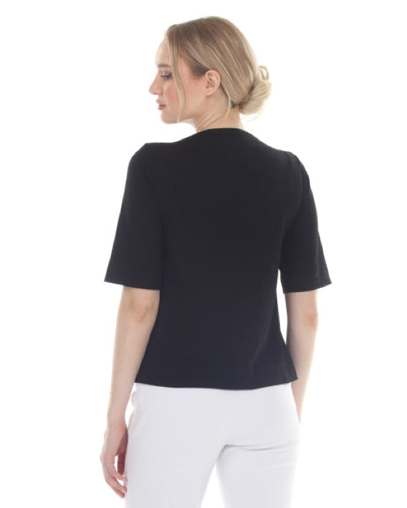 Woman wearing a black top and white pants on a white background