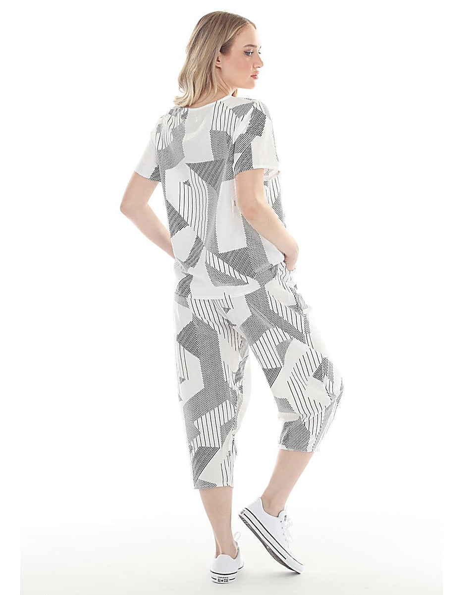 Woman wearing a geometric patterned outfit on a white background