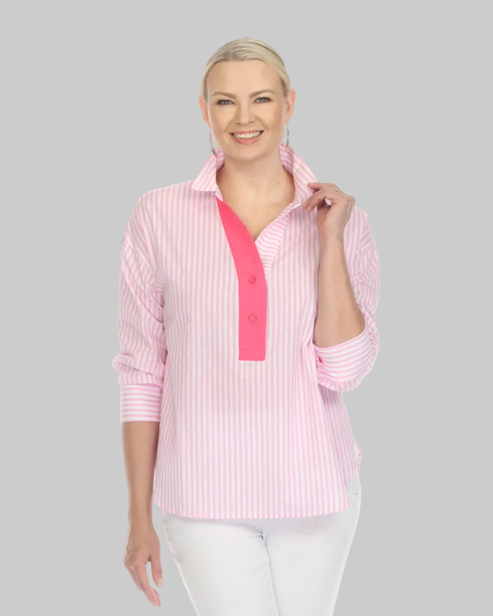 Woman wearing a pink striped shirt with a pink accent and white pants on a white background