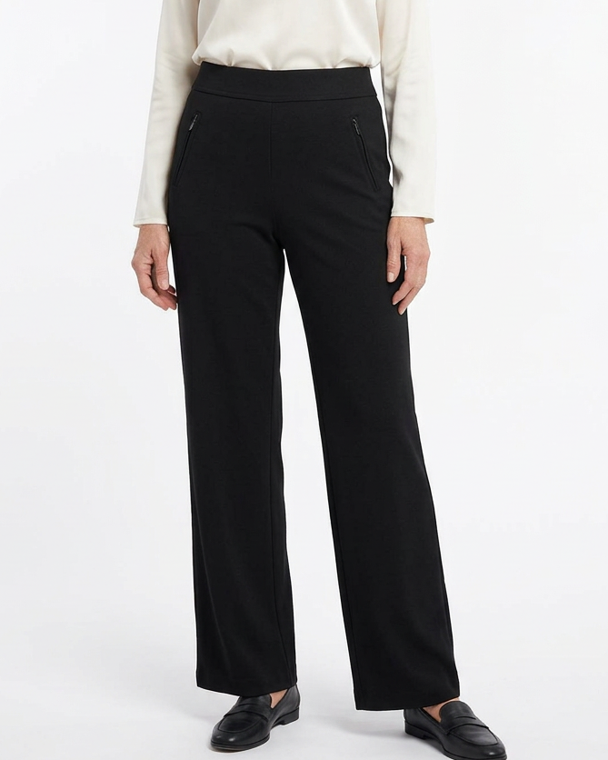 Mature model wearing the black pants on a white studio background