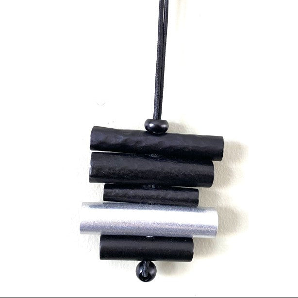 Black and silver cylindrical pendant on a white background