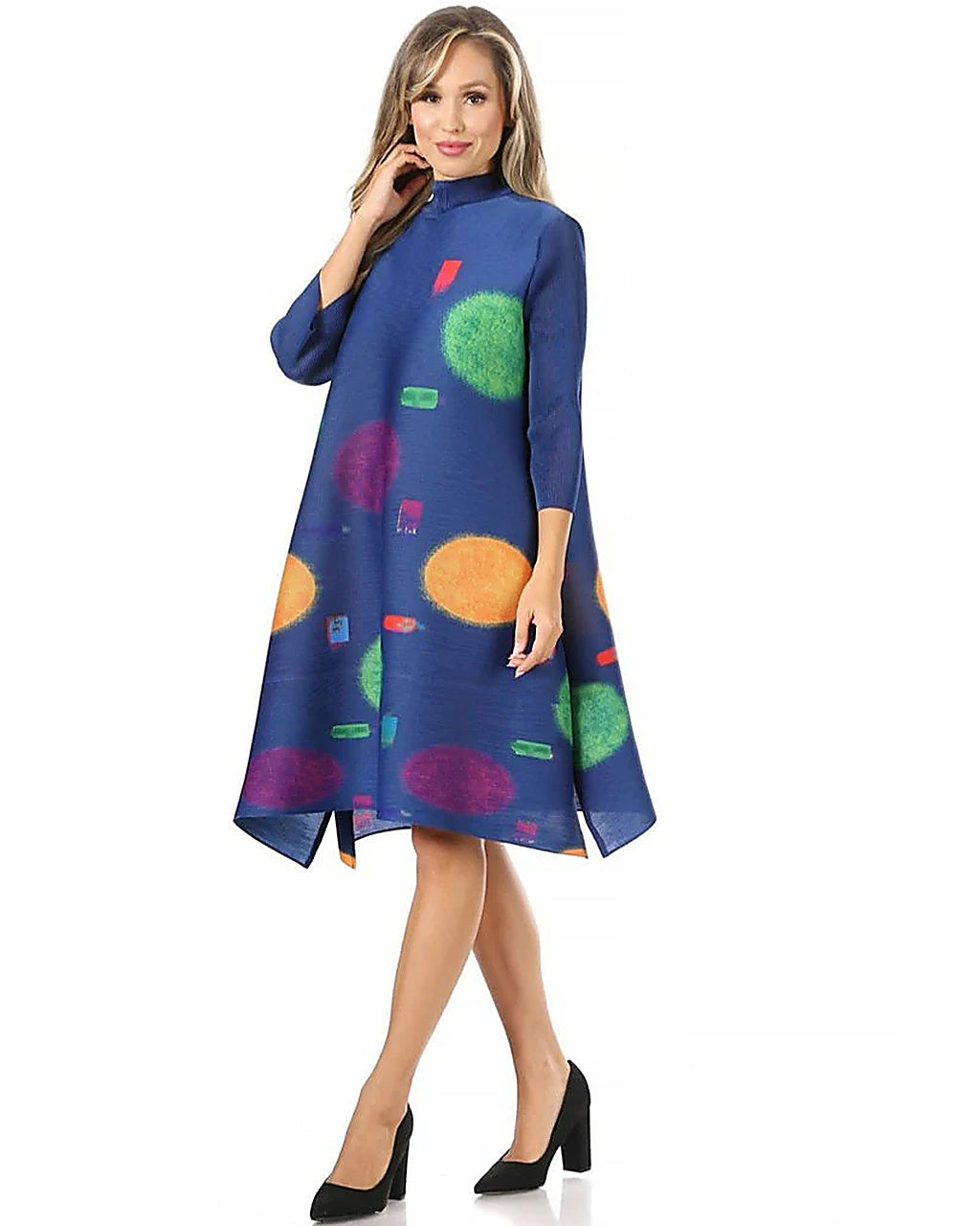 Woman wearing a blue dress with colorful abstract patterns on a white background